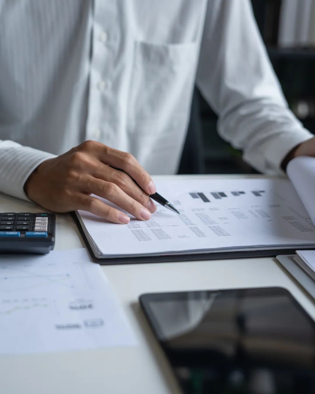 Equipa multicultural de gestores imobiliários portugueses reunida numa sala moderna, analisando documentos e sorrindo, ambiente profissional, luz natural, estilo documental, composição quadrada.