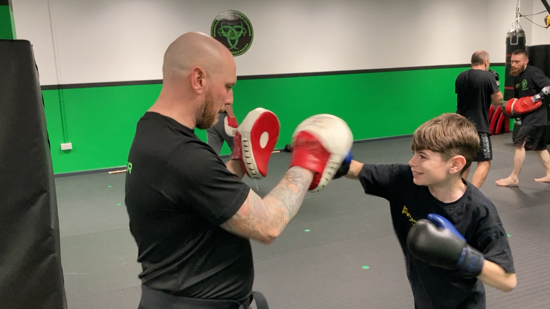 Teen and adult training partners practising striking drills