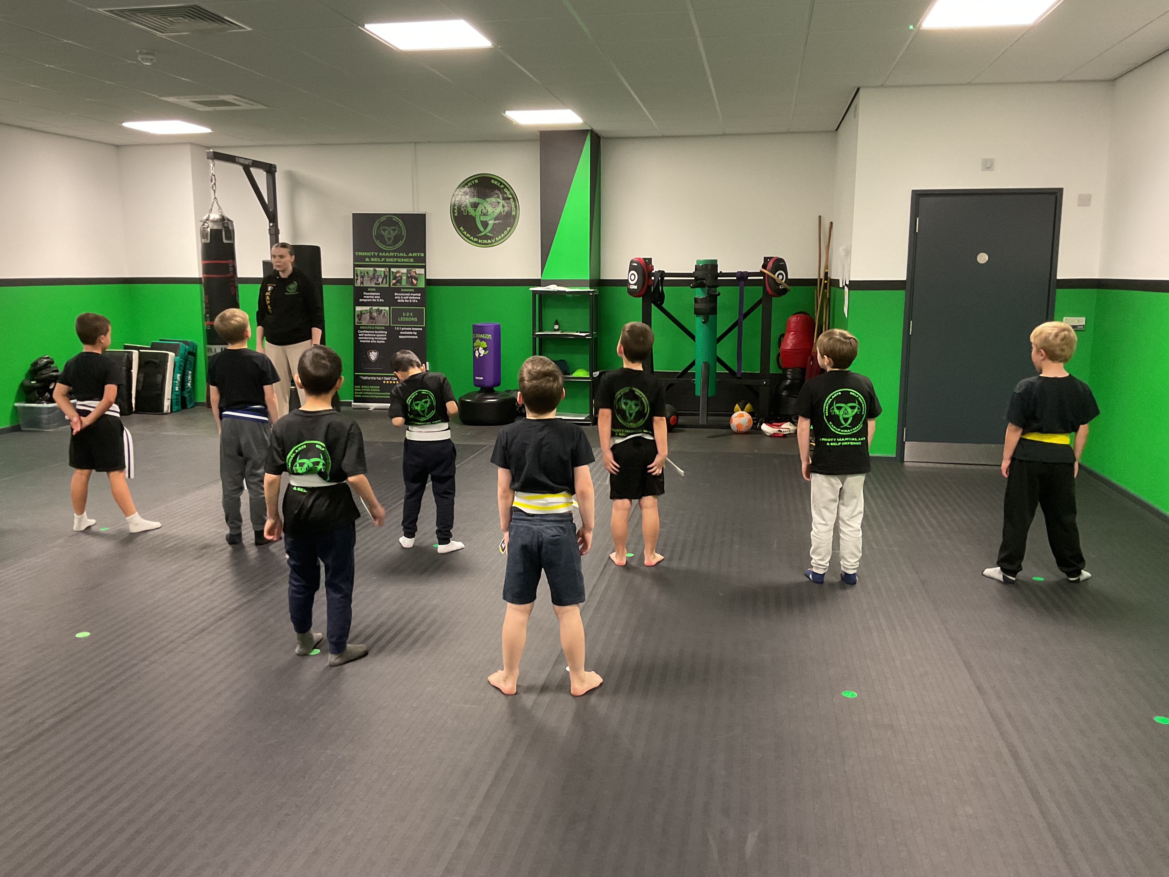 Children practising basic martial arts stances in a small group.