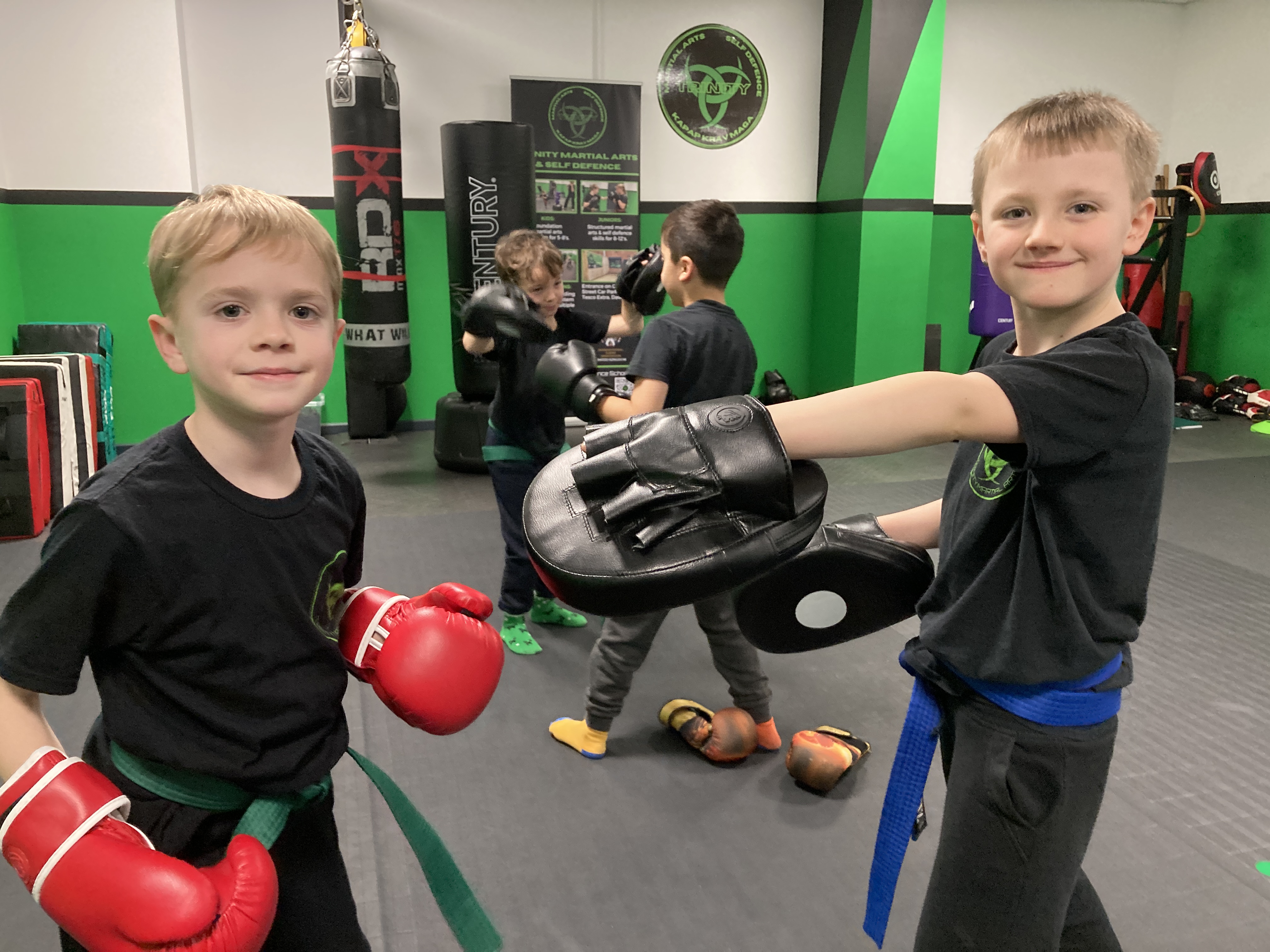 Children doing warm-up exercises led by a DBS-checked instructor.