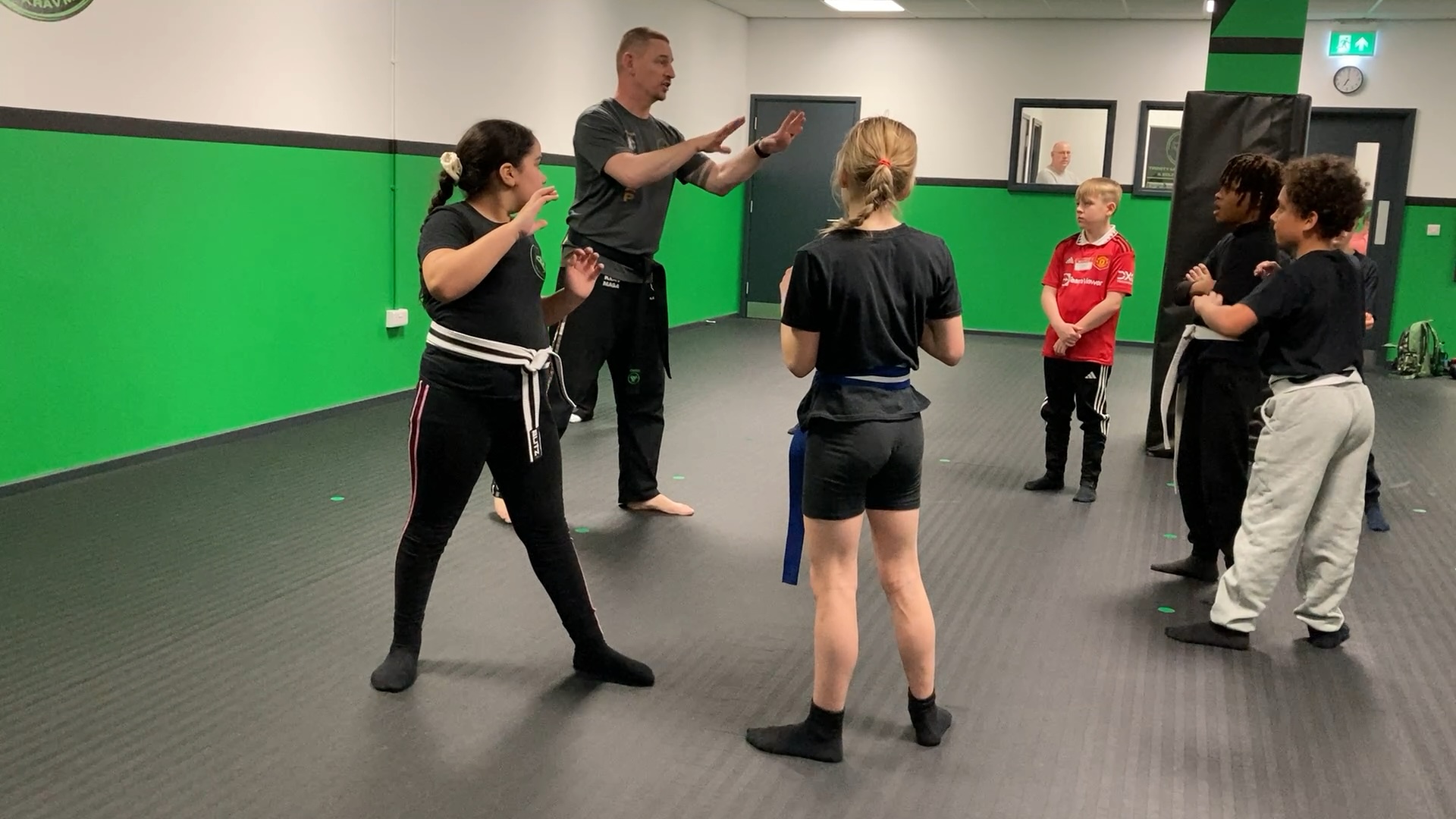 Instructor demonstrating a safe self-defence drill to a young student.