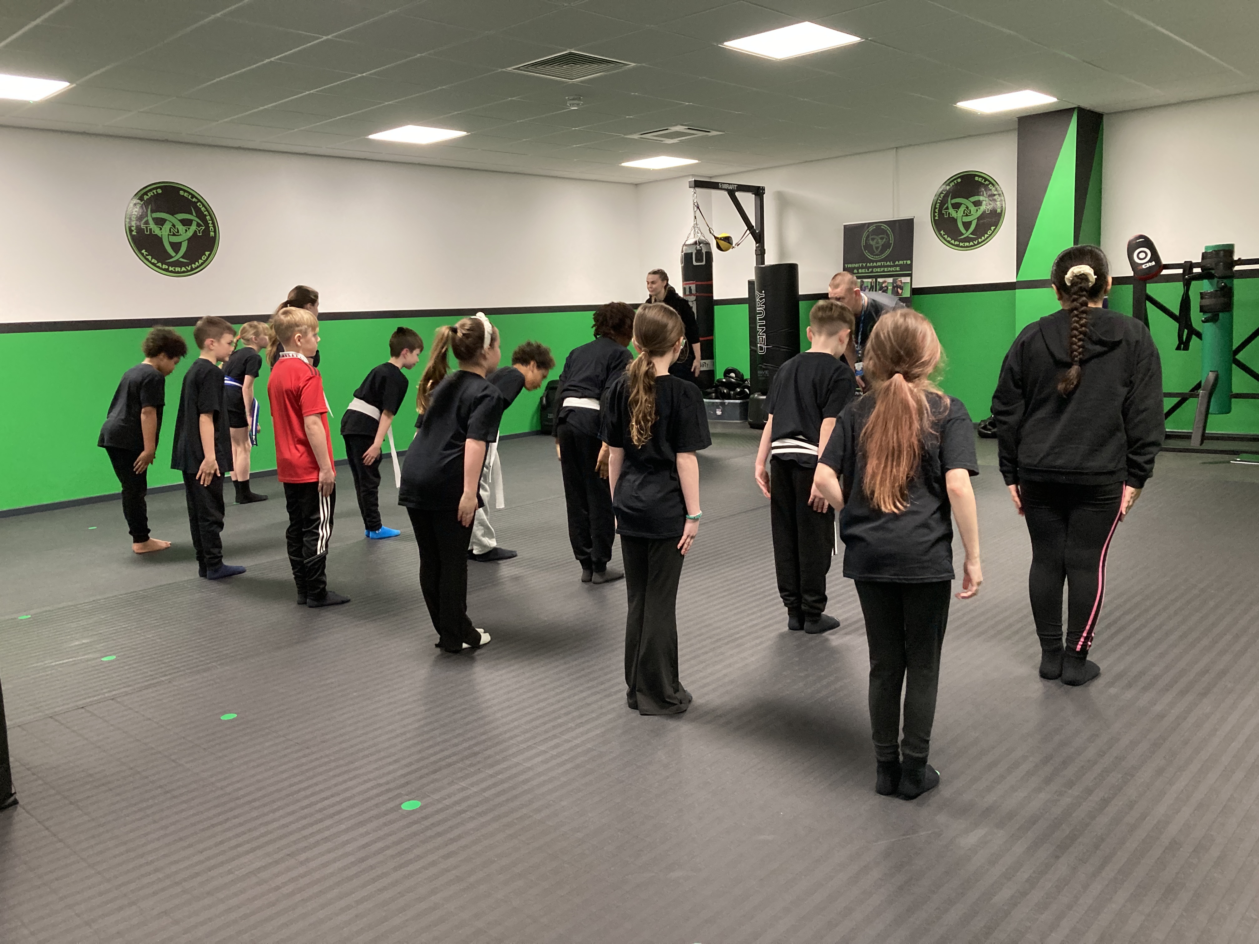 Instructor overseeing partner drills between 8–13-year-old students.