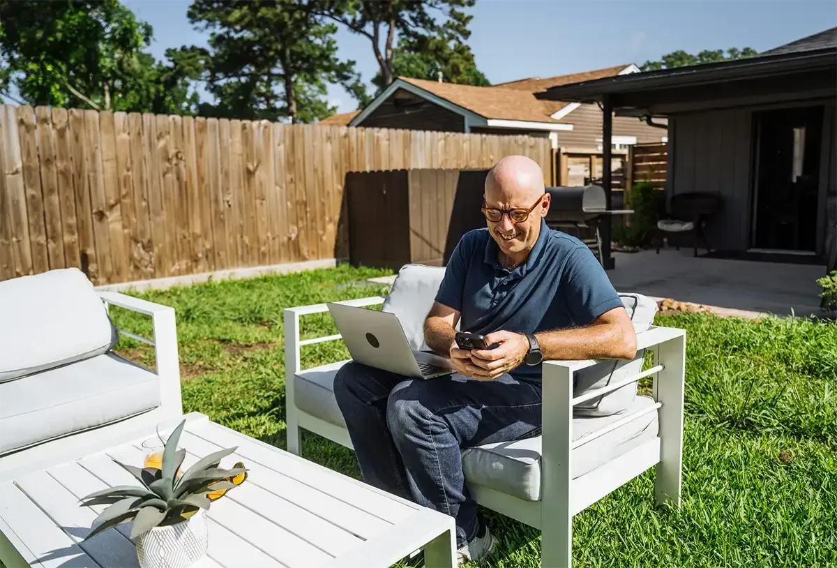 Homeowner standing confidently in front of their home at sunset, feeling relief and renewed control.