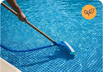 Person using a pool vacuum to clean water, emphasizing strong pool maintenance services by Strong Tower Pool.