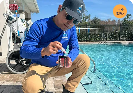 Person using a pool skimmer to clean debris from a sparkling blue swimming pool, illustrating Strong Tower Pool's maintenance services.