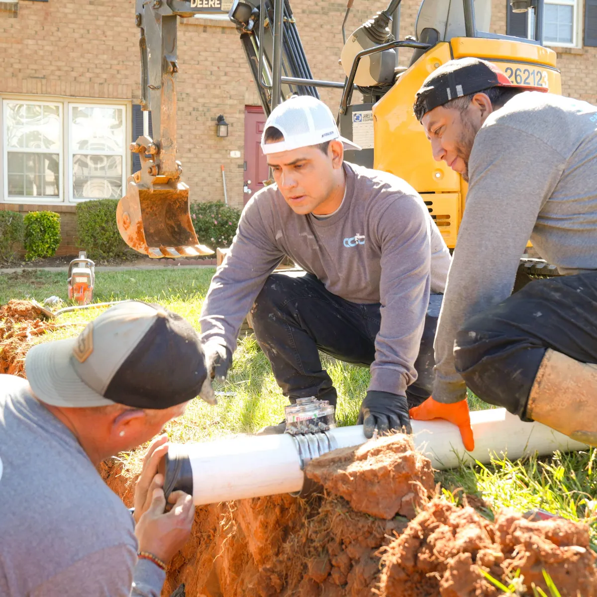 Carolina Clean Drains team connecting underground drain pipe during repair project