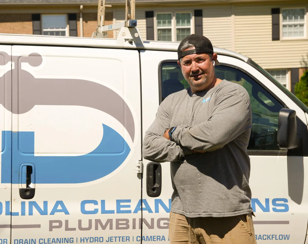 Owner of Carolina Clean Drains standing beside company service van in Charlotte NC