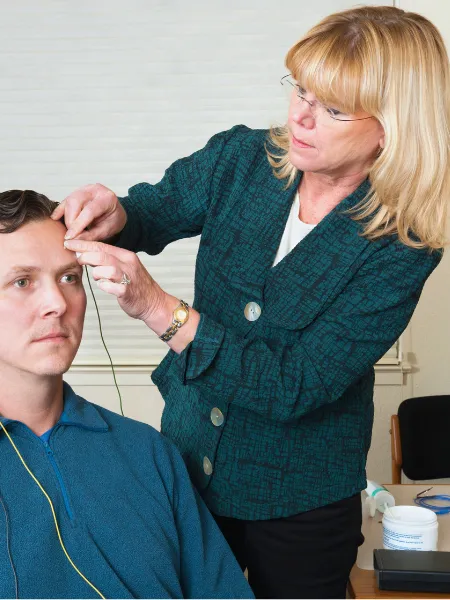  neurofeedback therapist helping a patient during his treatment