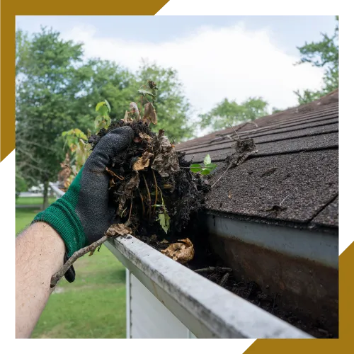 Technician removing debris during clogged gutter cleaning service