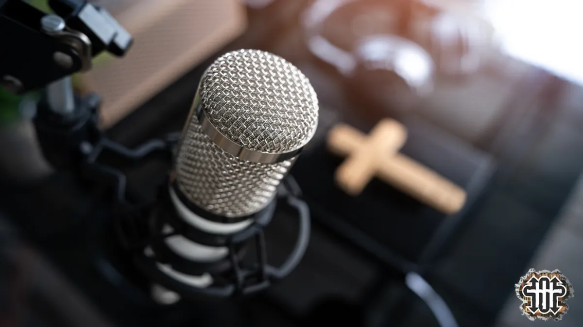 Podcast microphone with a Bible and cross in the background.