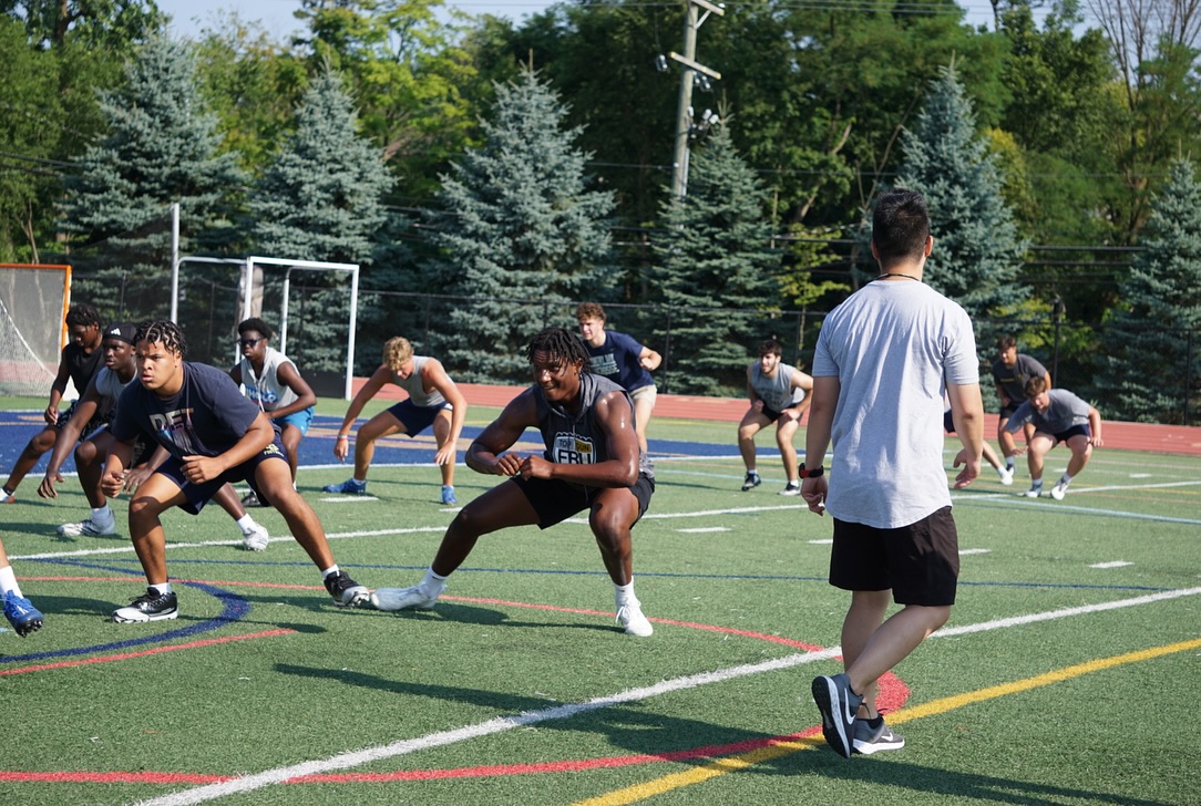 Youth and high school athletes completing outdoor turf training with Impact Sports Performance coaches