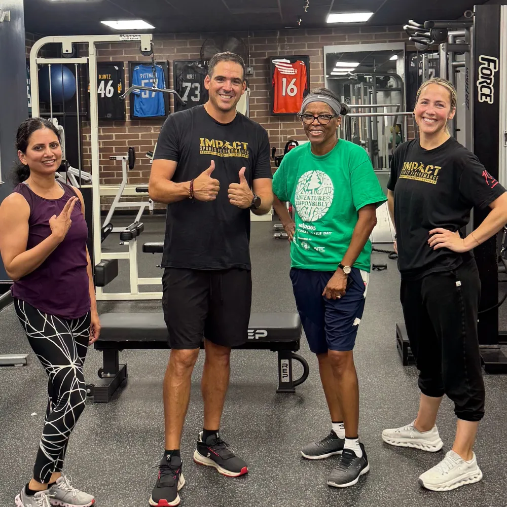 Adults participating in group fitness workout at Impact Sports Performance Novi