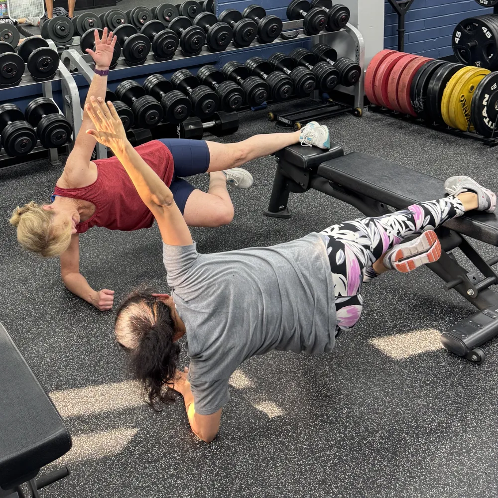 Adults performing strength exercises during small group training at Impact Sports Performance