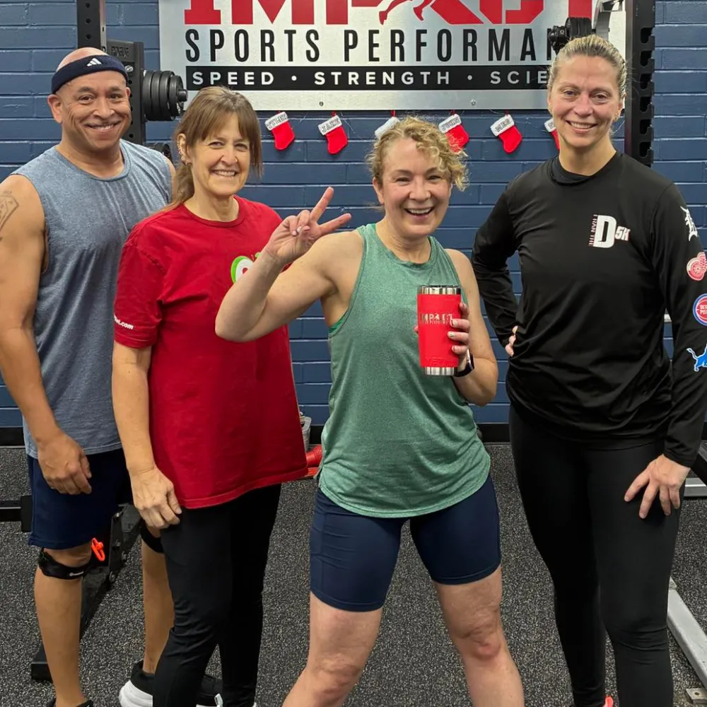 Group of adult personal training clients smiling after workout at Impact Sports Performance Novi