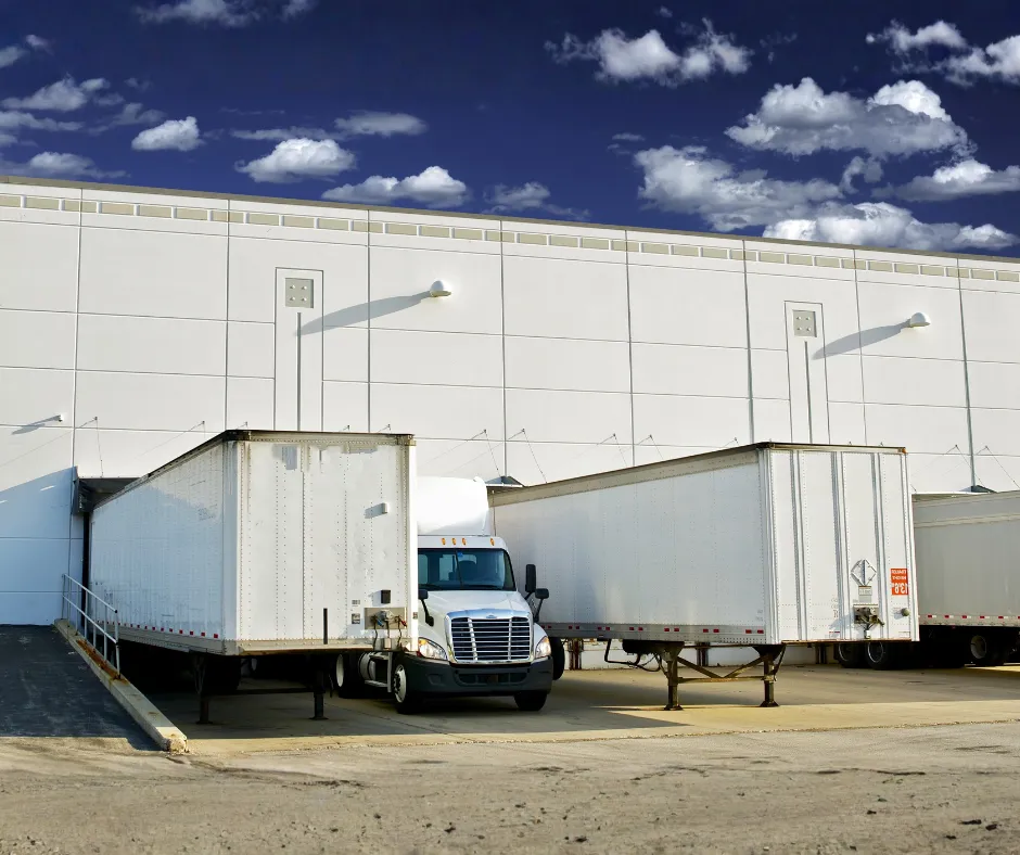 Cross-border logistics hub with trucks, loading docks, and customs office