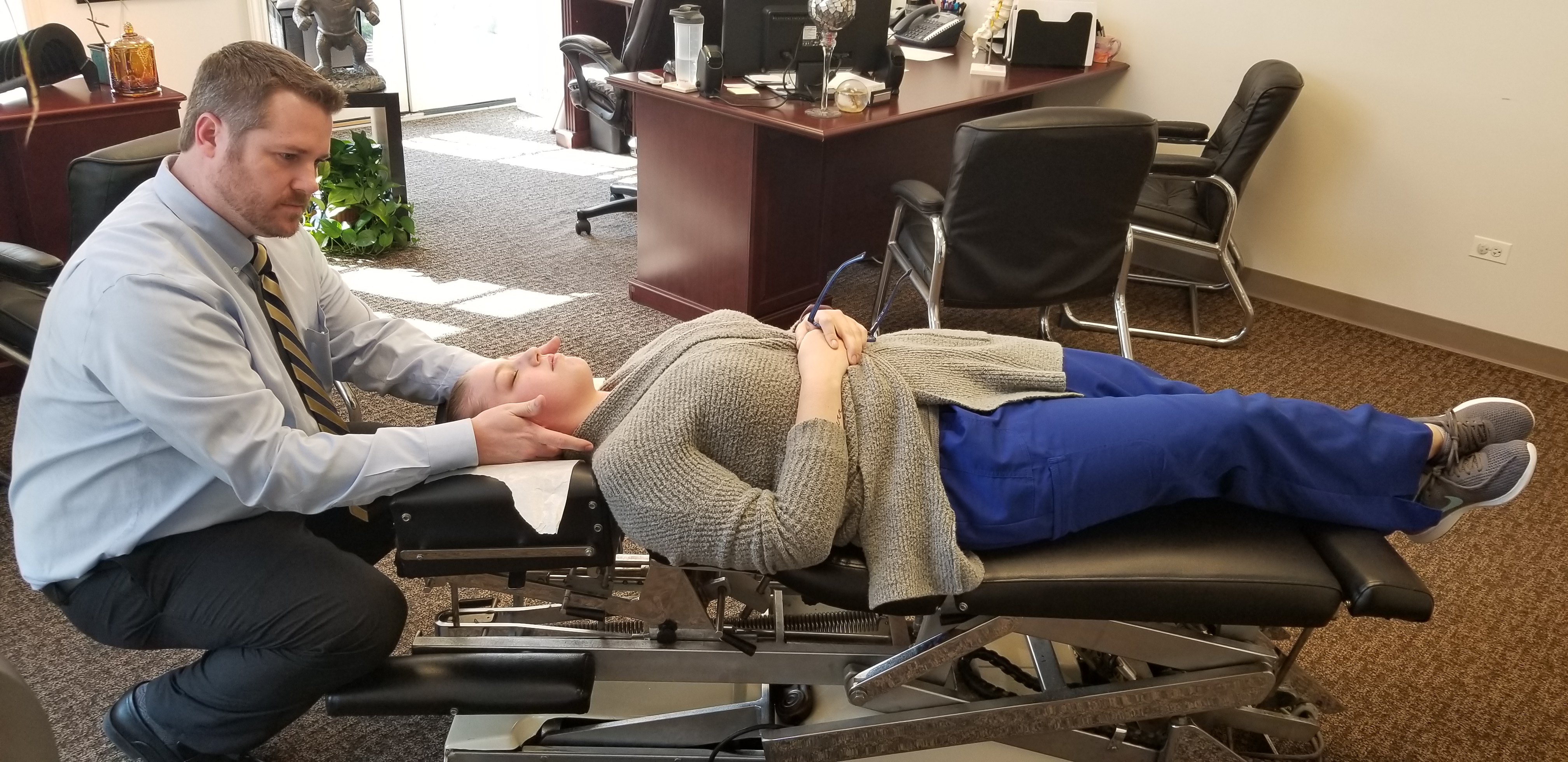 Chiropractor adjusting patient in a bright, modern clinic