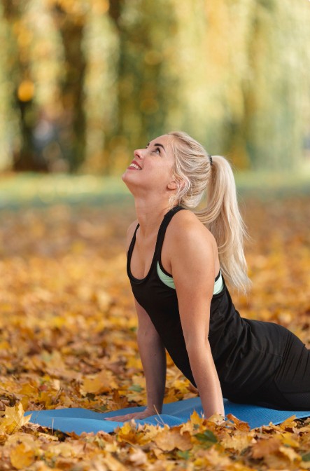 woman doing yoga in a park, experiencing serenity after visiting a top acupuncture clinic in woodbury mn.
