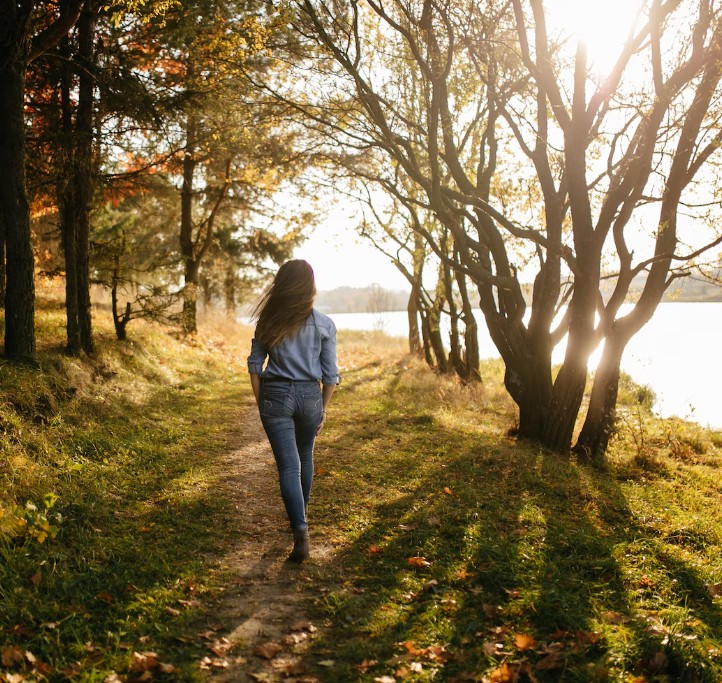 woman walking peacefully by a lake, finding calm with support from an acupuncture clinic in woodbury mn.