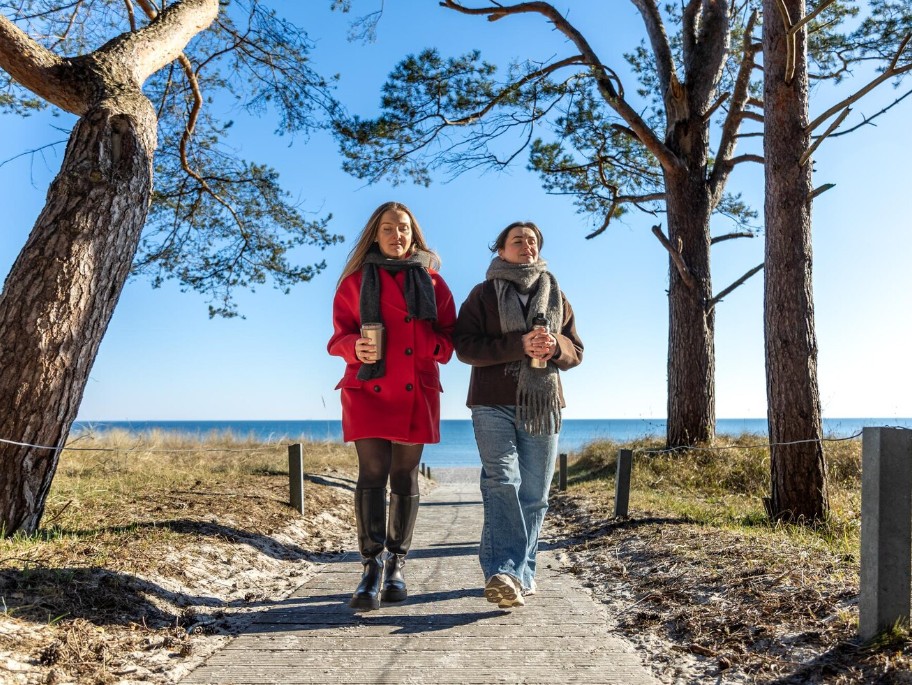 two women walking happily on a beach path, enjoying good health from an acupuncture clinic in woodbury mn.