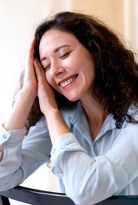 woman smiling with eyes closed, finding relief from pain and stress with a herbal medicine practitioner in woodbury mn.
