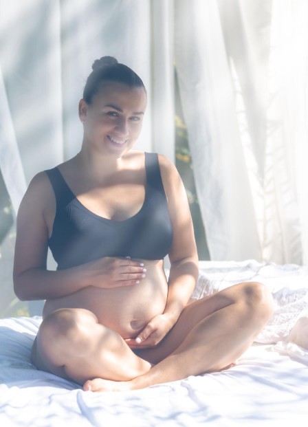 smiling pregnant woman feeling healthy and supported by the women's health acupuncture clinic in woodbury mn.