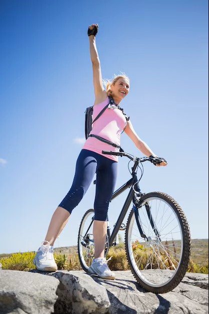 woman celebrating feeling healthy and active on her bike after alternative medicine practitioner treatment in woodbury mn.