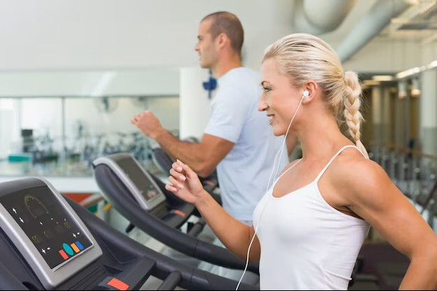 couple running comfortably on treadmills after recovery at a leading acupuncture clinic in woodbury mn.