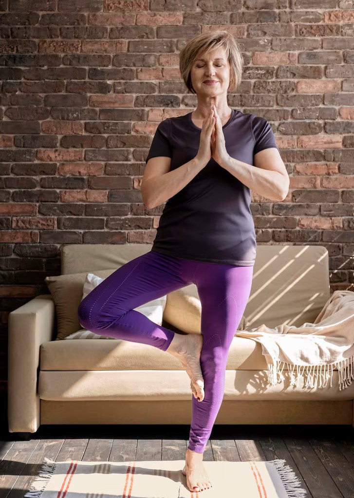 veteran feeling relaxed and comfortable in a yoga tree pose at home after veterans acupuncture in woodbury mn.