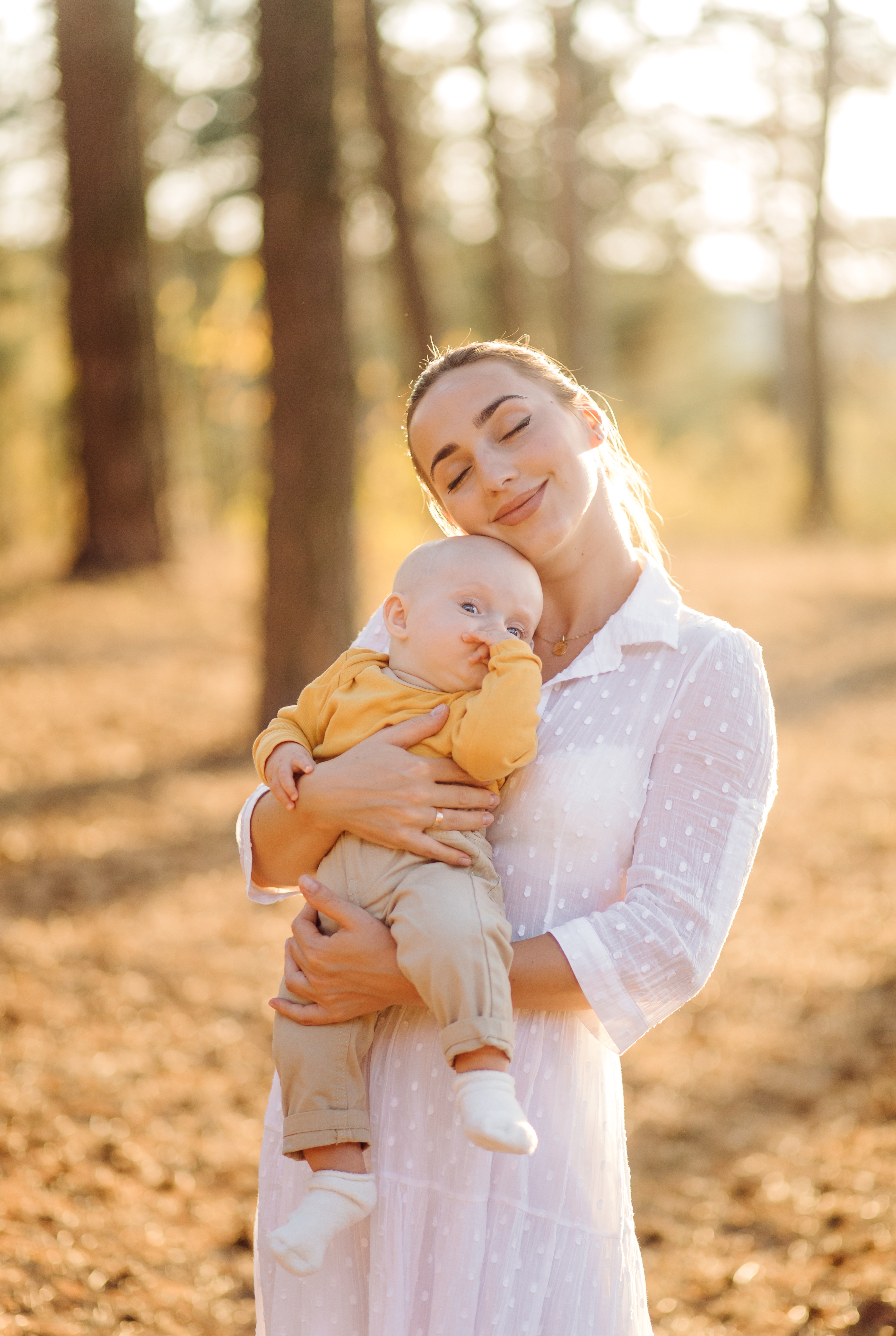 mother cradling her baby son in the sun, enjoying the result of care from woodbury mn fertility clinic.