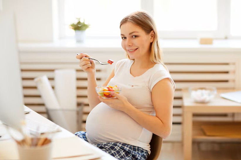 pregnant woman enjoying a healthy salad, a benefit of working with a fertility acupuncture clinic in woodbury mn.