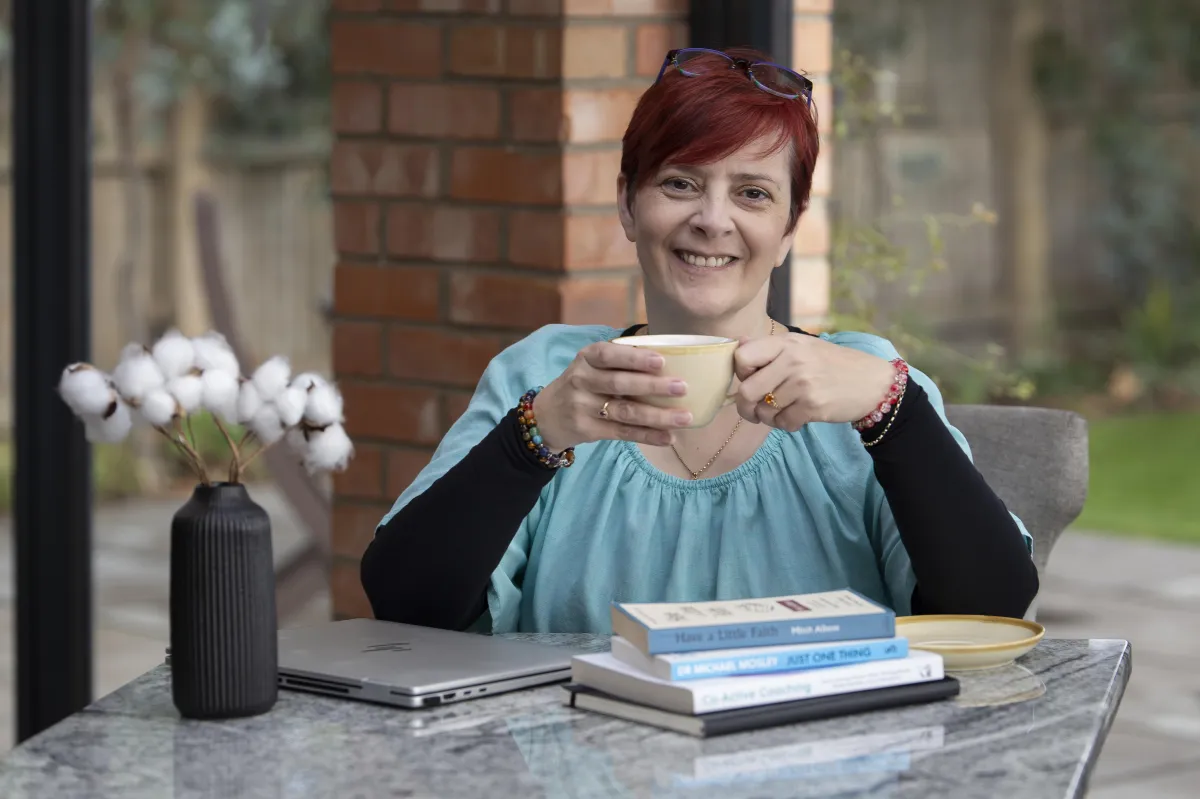 Photo of Sarah Chilvers smiling holding a cup of tea