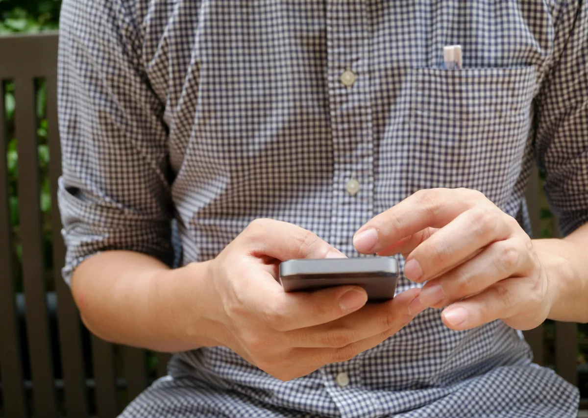 Man on phone controlling home temperature. 