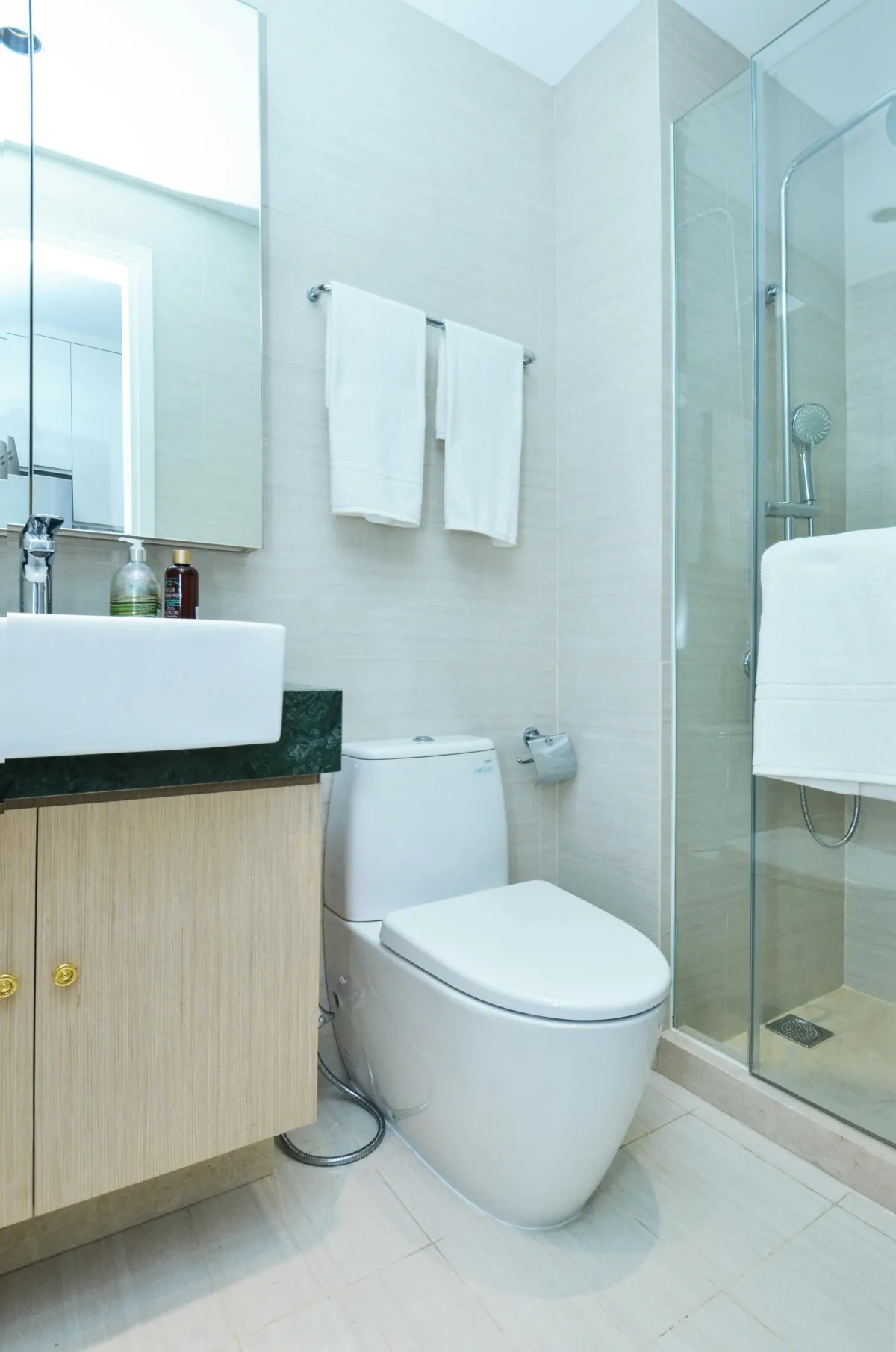 Modern bathroom with sink, glass shower, and toilet.