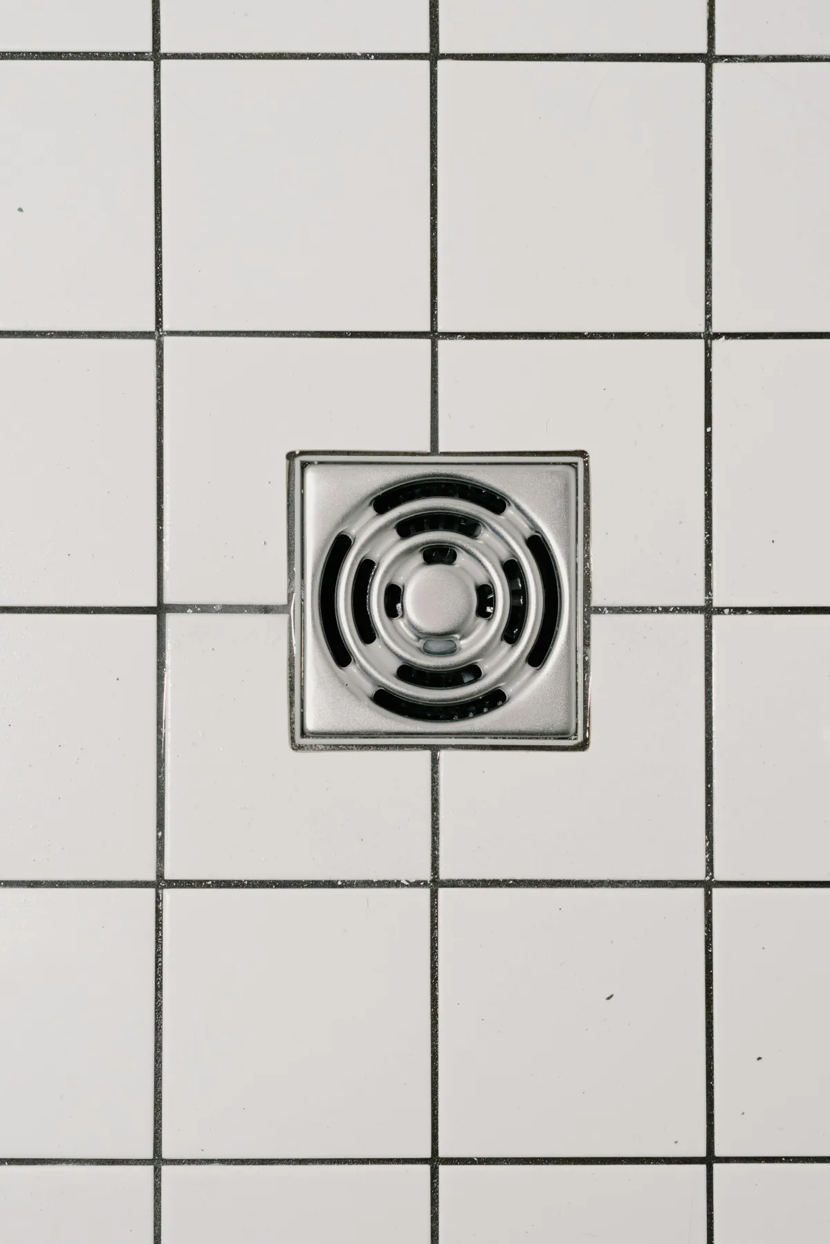 Shower drain with a tile flooring.