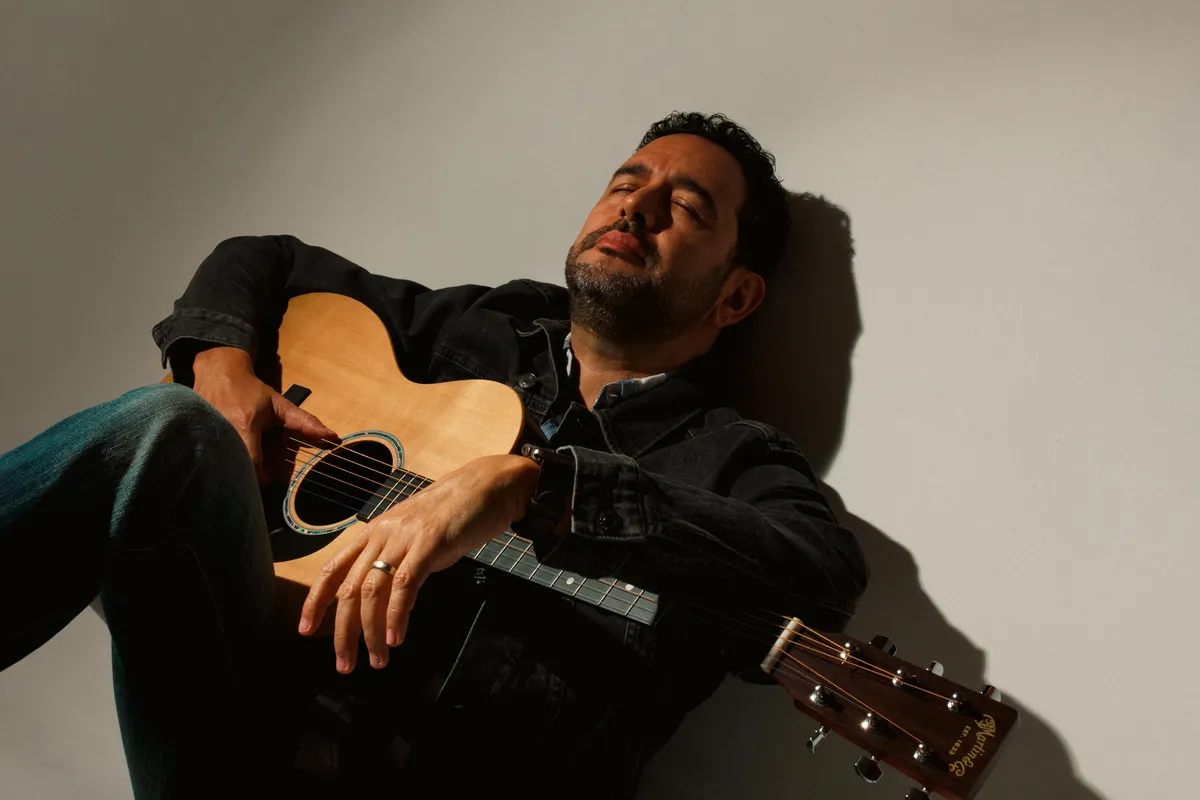 Aaron Sztarkman performing live acoustic guitar and connecting with an engaged audience in an intimate venue setting