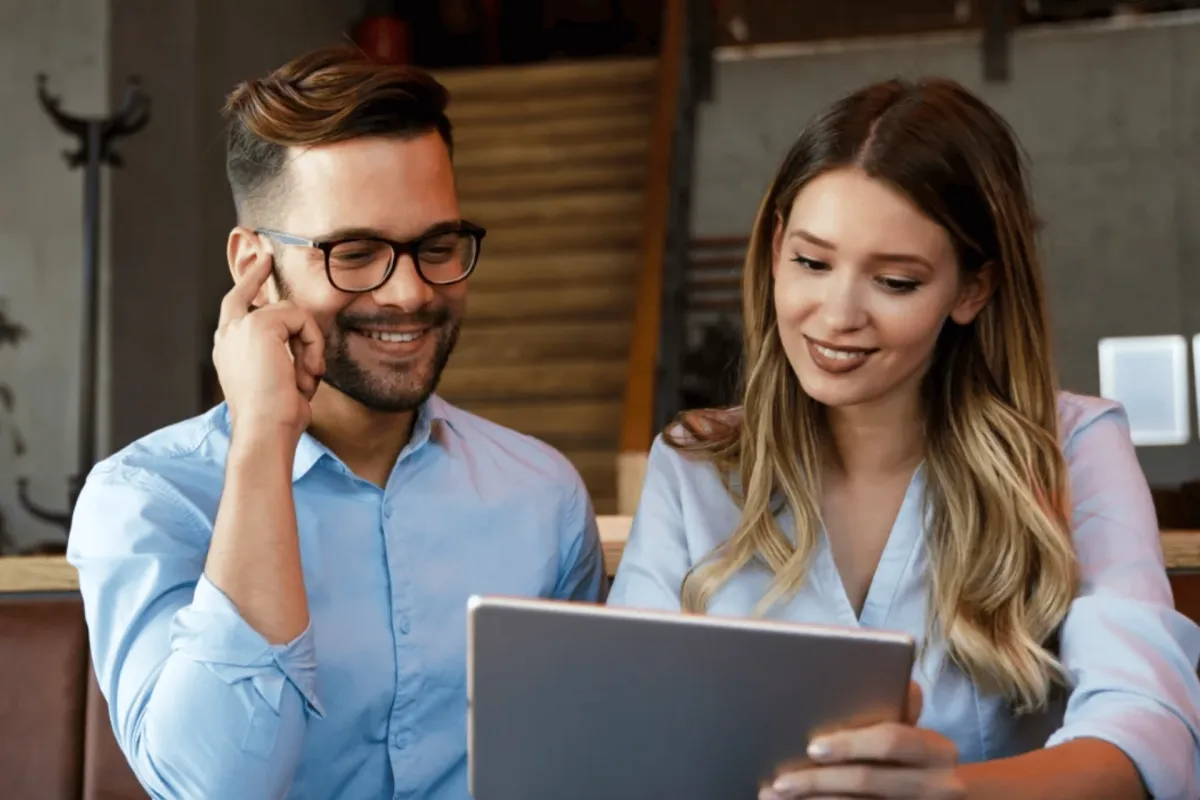 Couple reviewing information together on a tablet indoors
