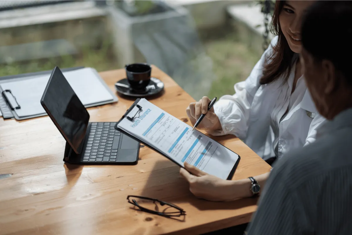 Advisor reviewing a health insurance form with a client at a table