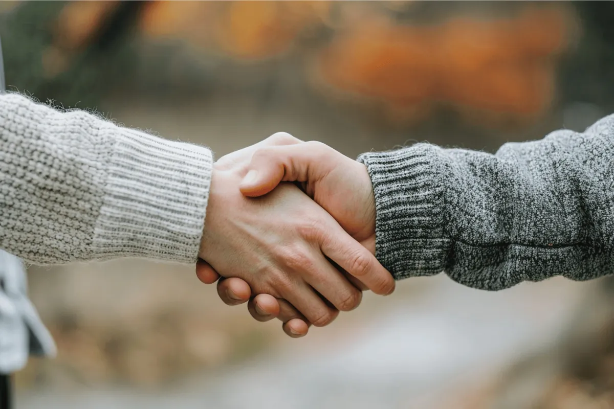 Close-up of two people shaking hands outdoors