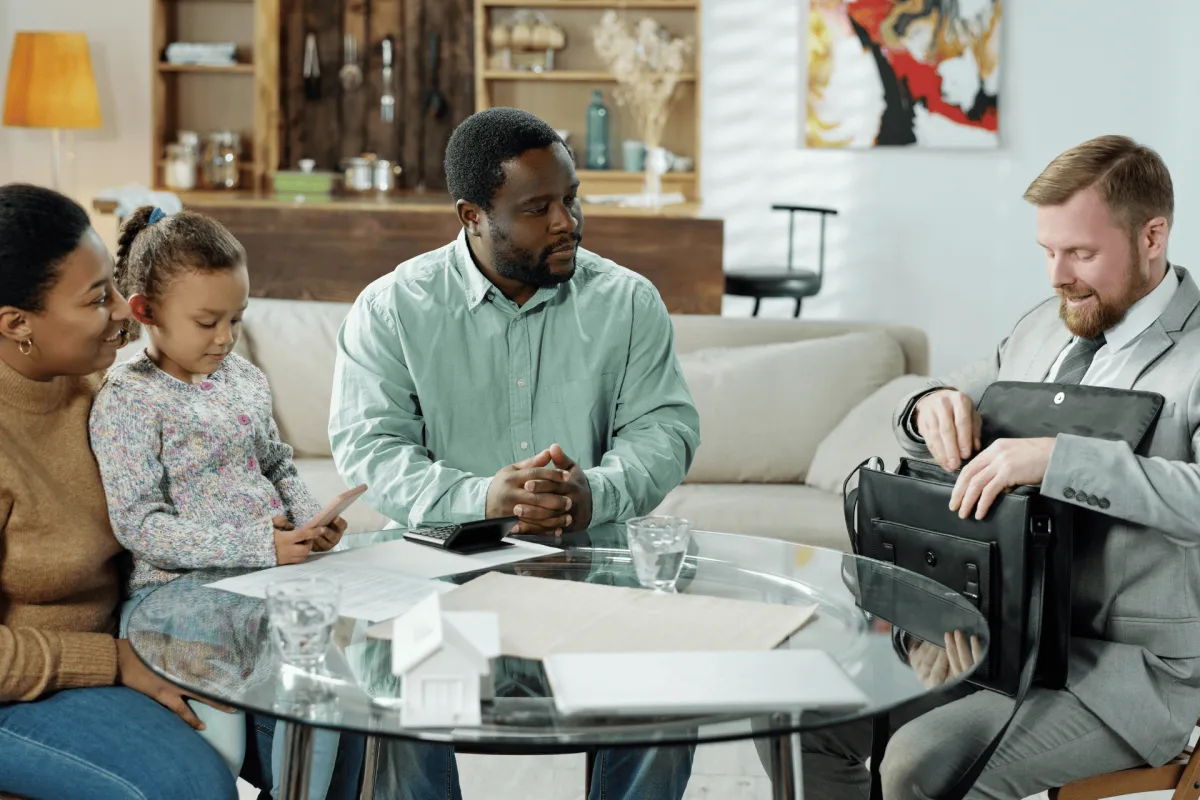 Advisor meeting with a family around a table in their home