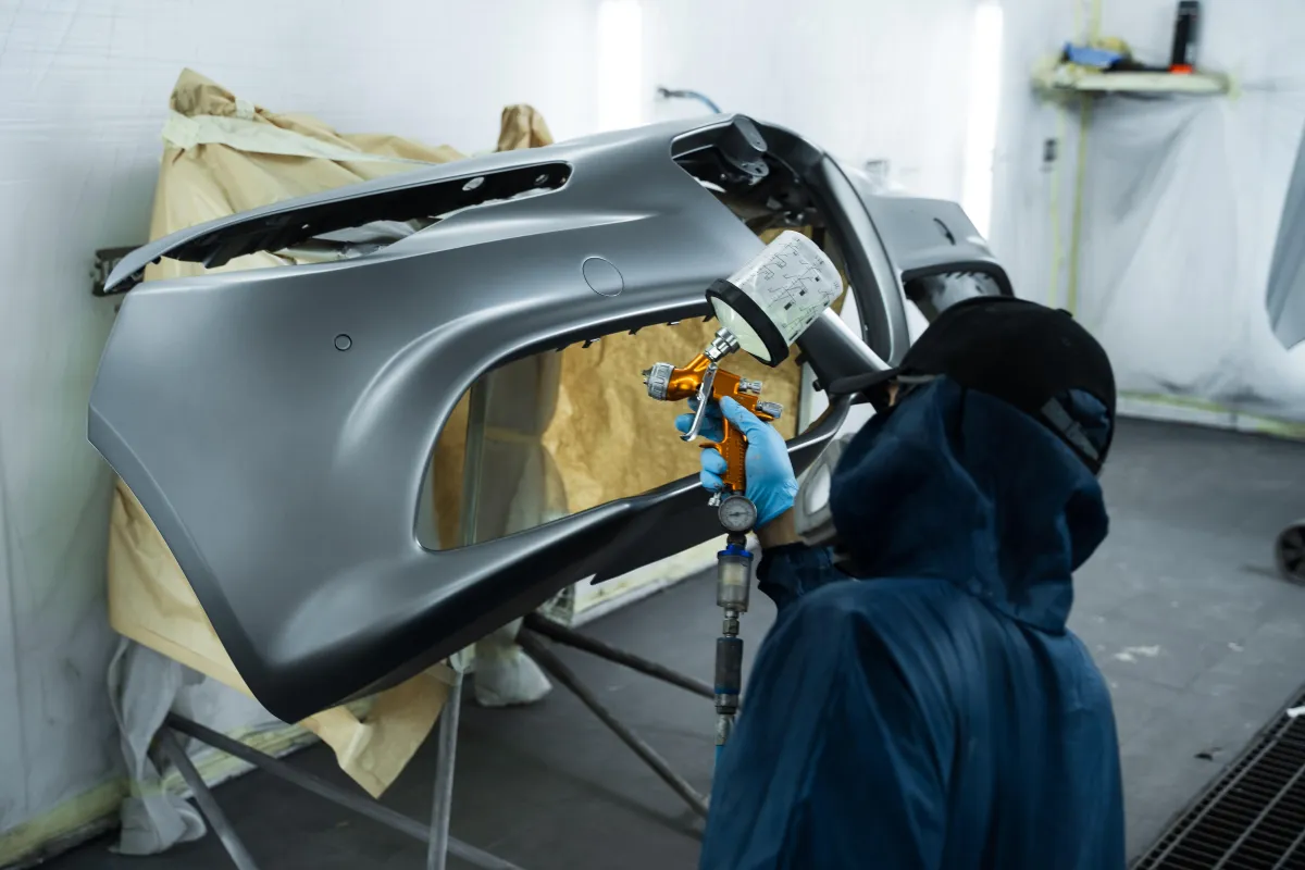 Hands using a digital caliper to measure metal part.