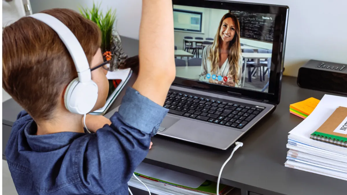 Child waves at laptop