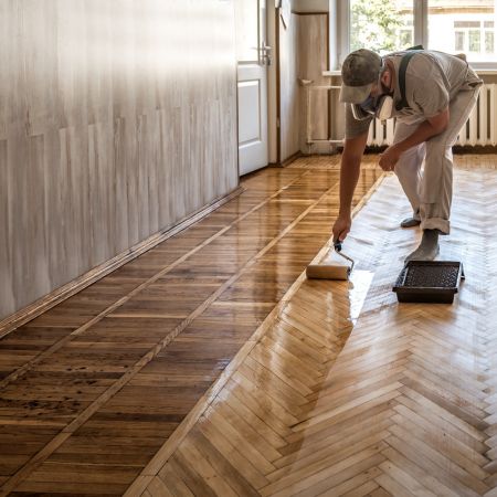 man refinishing a floor