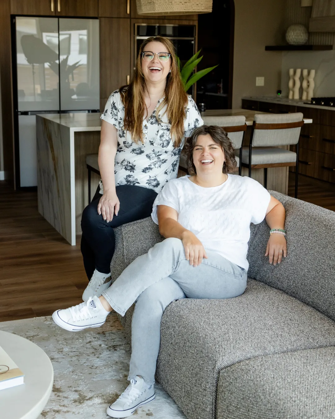 Kim and Kat smiling with raised hands in a casual pose on a transparent background.