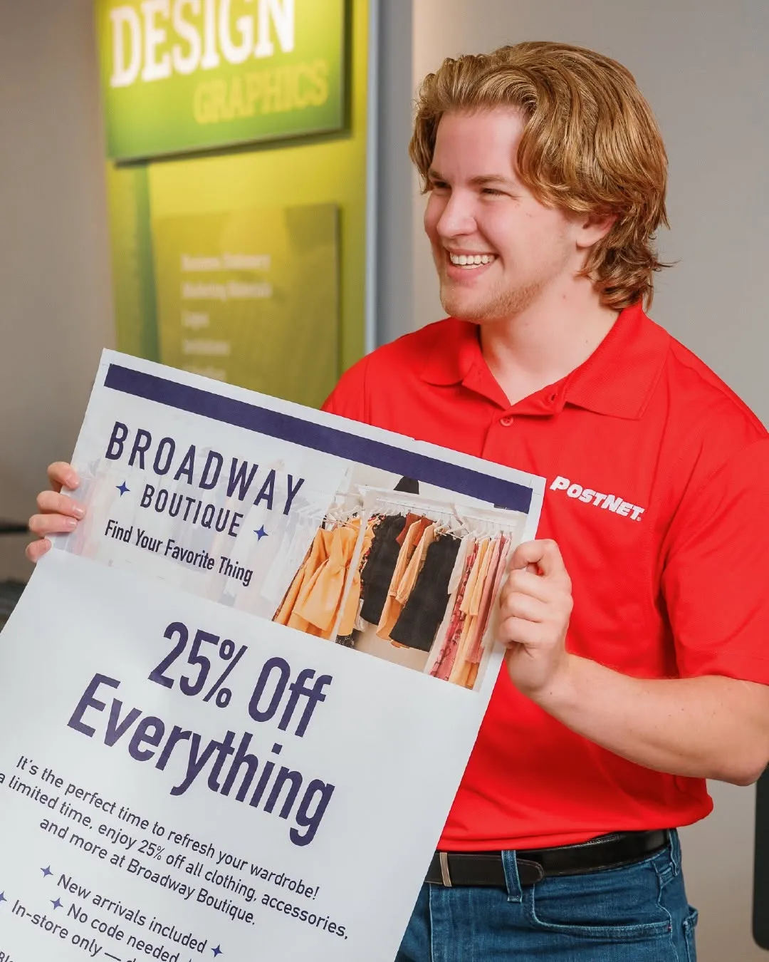 PostNet staff member holding a printed promotional poster.