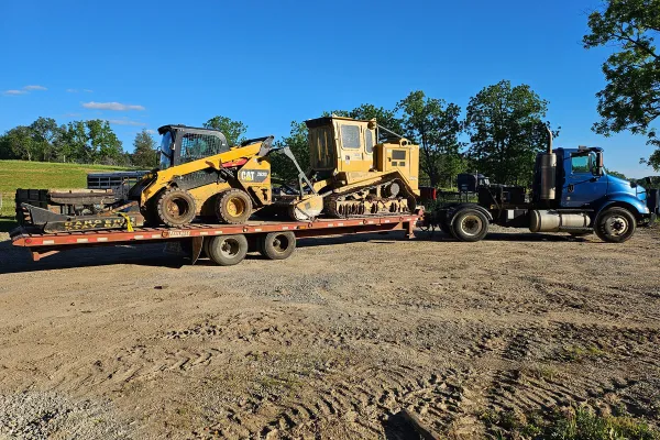 Skid steer with brush hog cutting thick brush