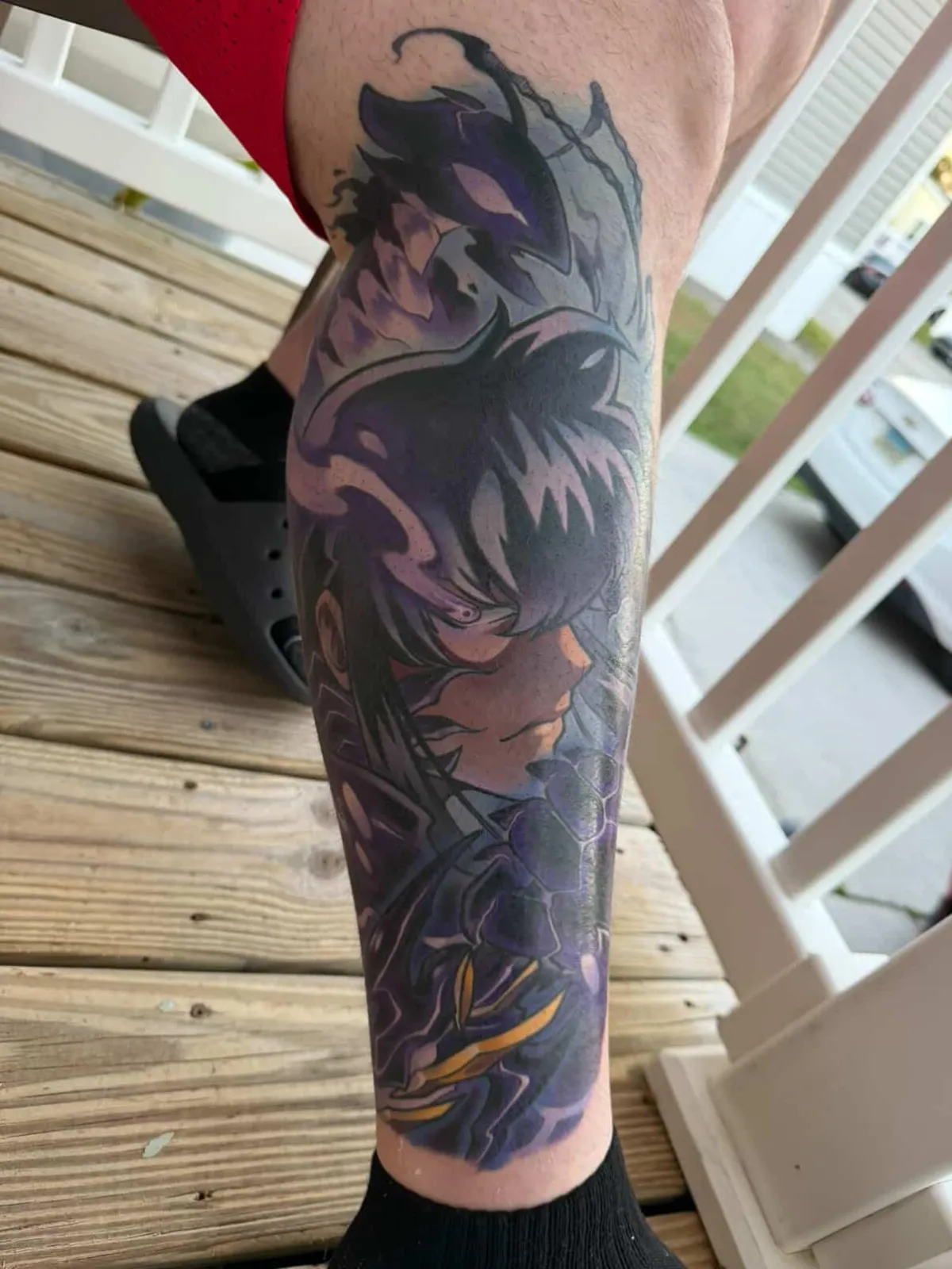 Fully healed anime tattoo of Sung Jinwoo from Solo Leveling by Orlando Anime Tattoo Artist Ren Behan. This Solo Leveling tattoo features stark blacks against vibrant purples to really emphasize glowing effects.
