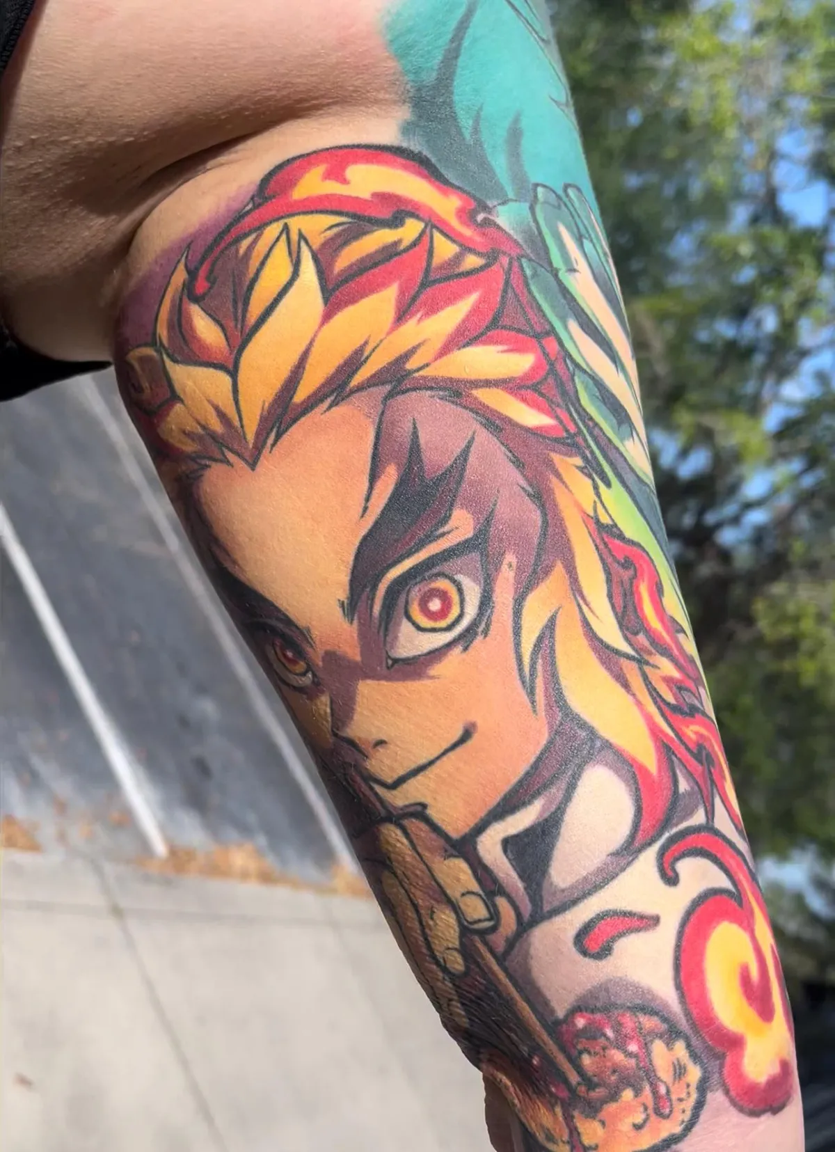 Fully healed anime tattoo of Rengoku from Demon Slayer by Orlando anime tattoo artist Ren Behan. This Rengoku tattoo has stunning reds and golds that contrast beautifully against the bold linework.