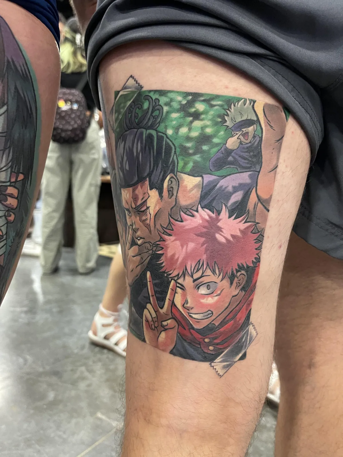 Fully healed anime tattoo of Todo and Yuji from JJK by Orlando Anime Tattoo Artist Ren Behan. This JJK tattoo is designed to be as if Todo and Yuji were taking a selfie, with Gojo photobombing the background.