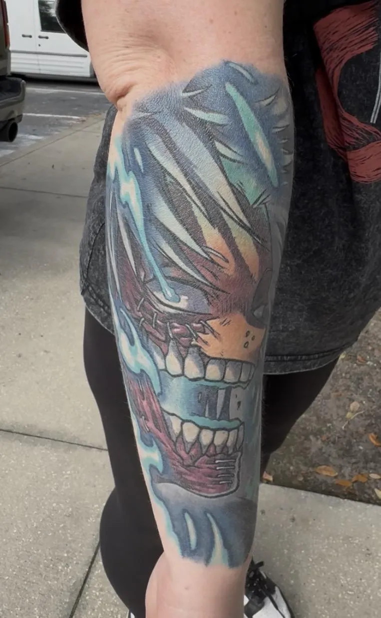 Fully healed anime tattoo of Dabi from My Hero Academia by Orlando Anime Tattoo Artist Ren Behan. This fiery Dabi tattoo features blue flames and his unsettling grin.