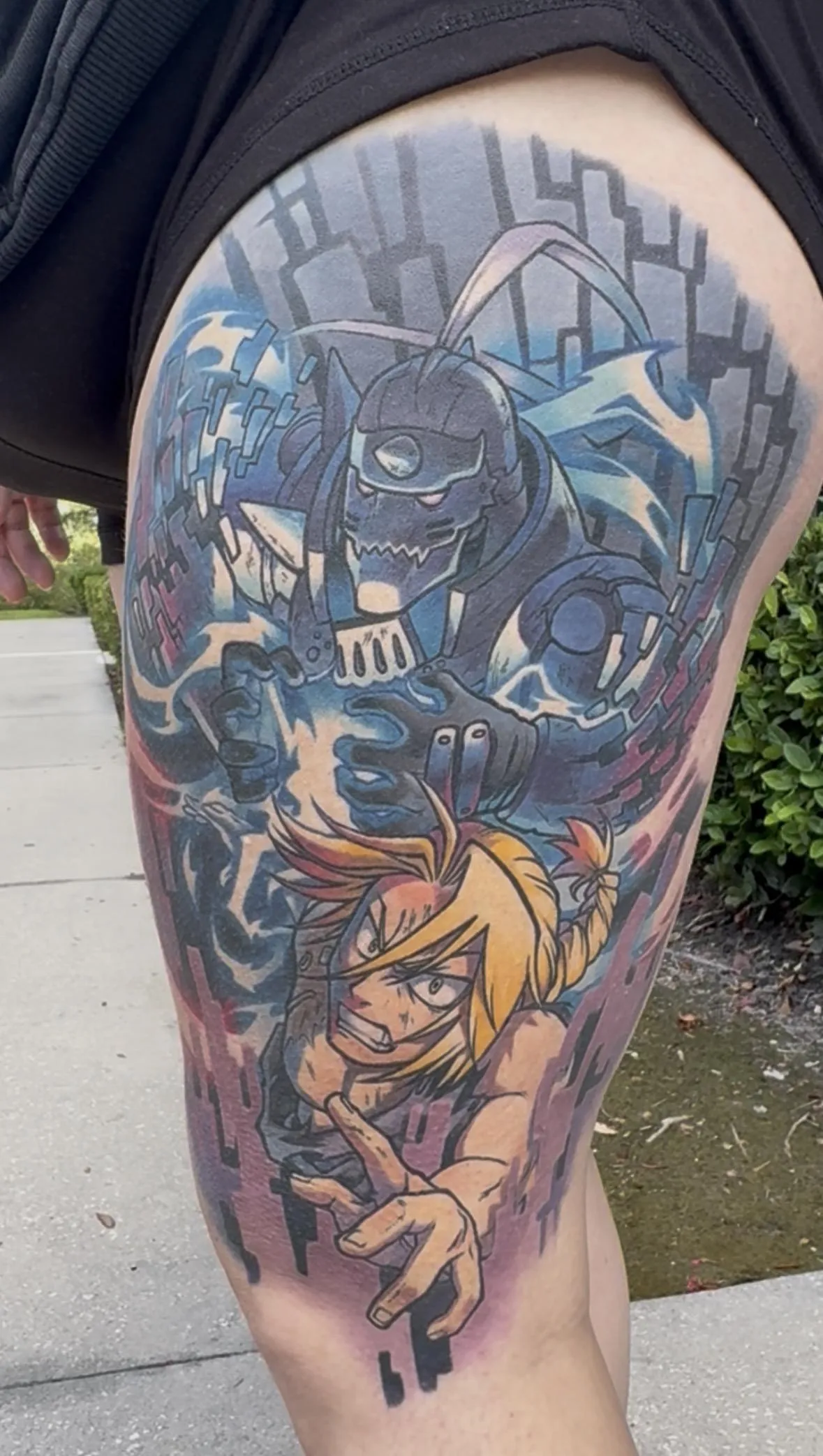 Fully healed anime tattoo of the Elric Brothers from Full Metal Alchemist by Orlando Anime Tattoo Artist Ren Behan. This tattoo of Edward and Alphonse Elric features remarkable details, glowing effects, and rich colors.